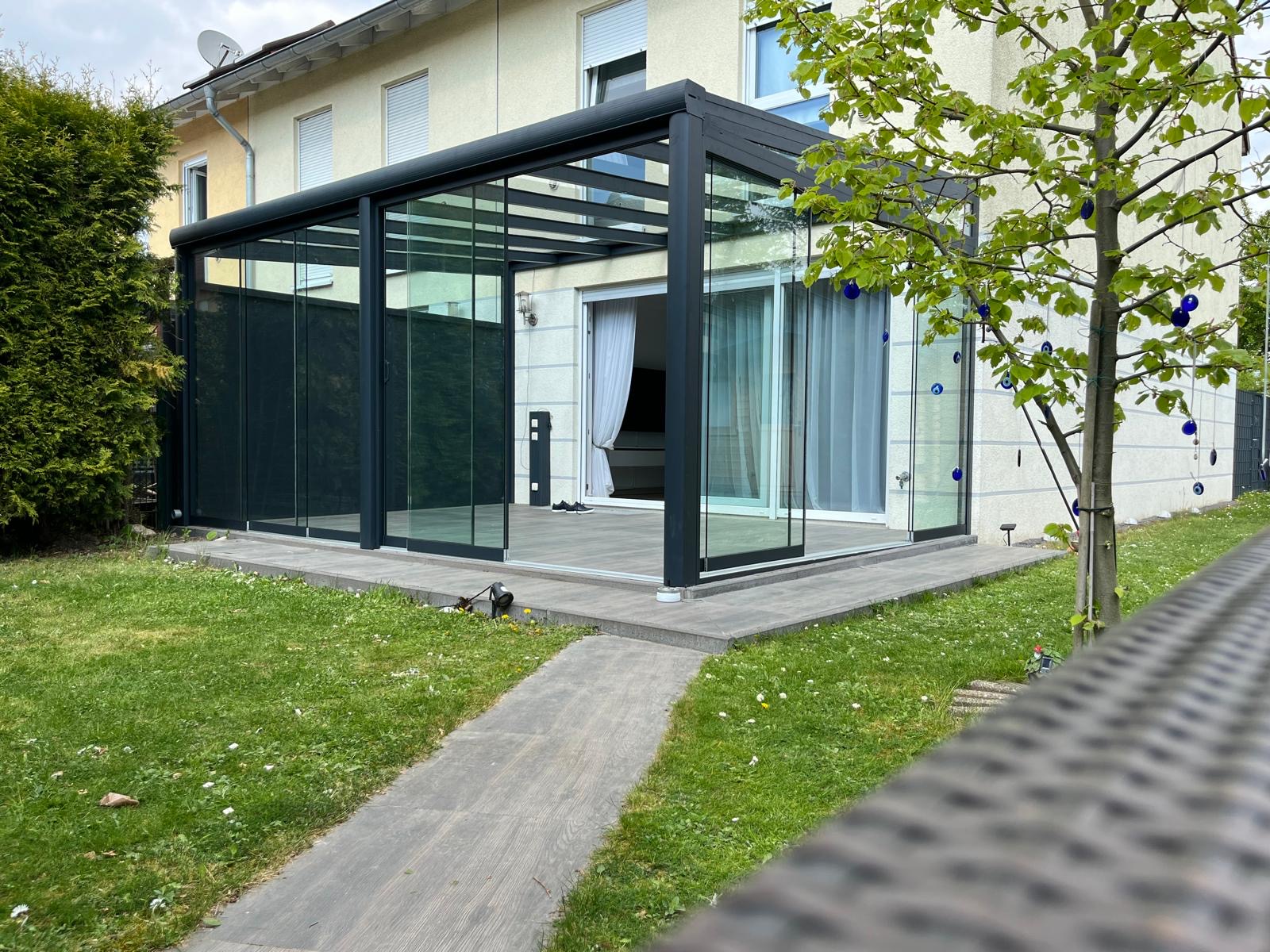 Moderner Sommergarten mit Glasüberdachung